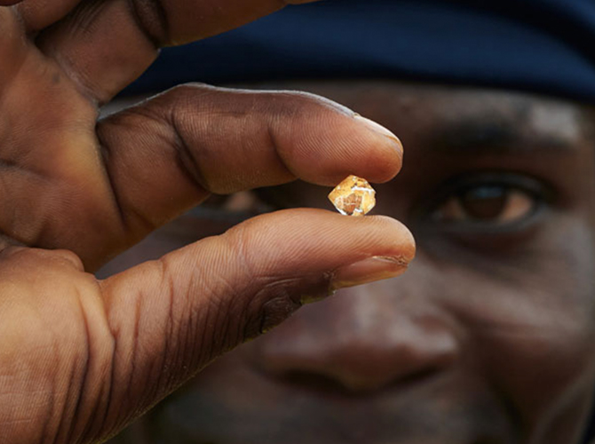 A miner shows off the estimated 5 to 7 carat diamond