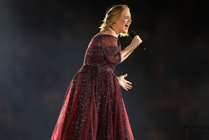 Adele performing on stage in red dress